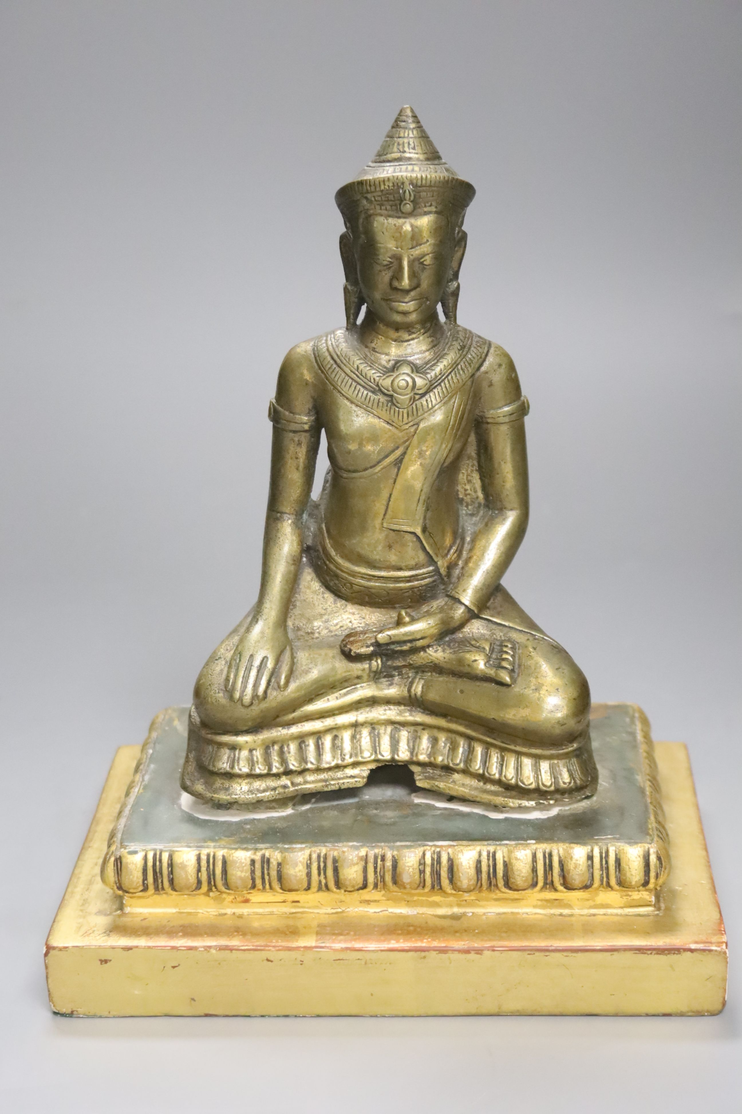 A South East Asian engraved and polished bronze figure of a seated deity, H 19.5cm